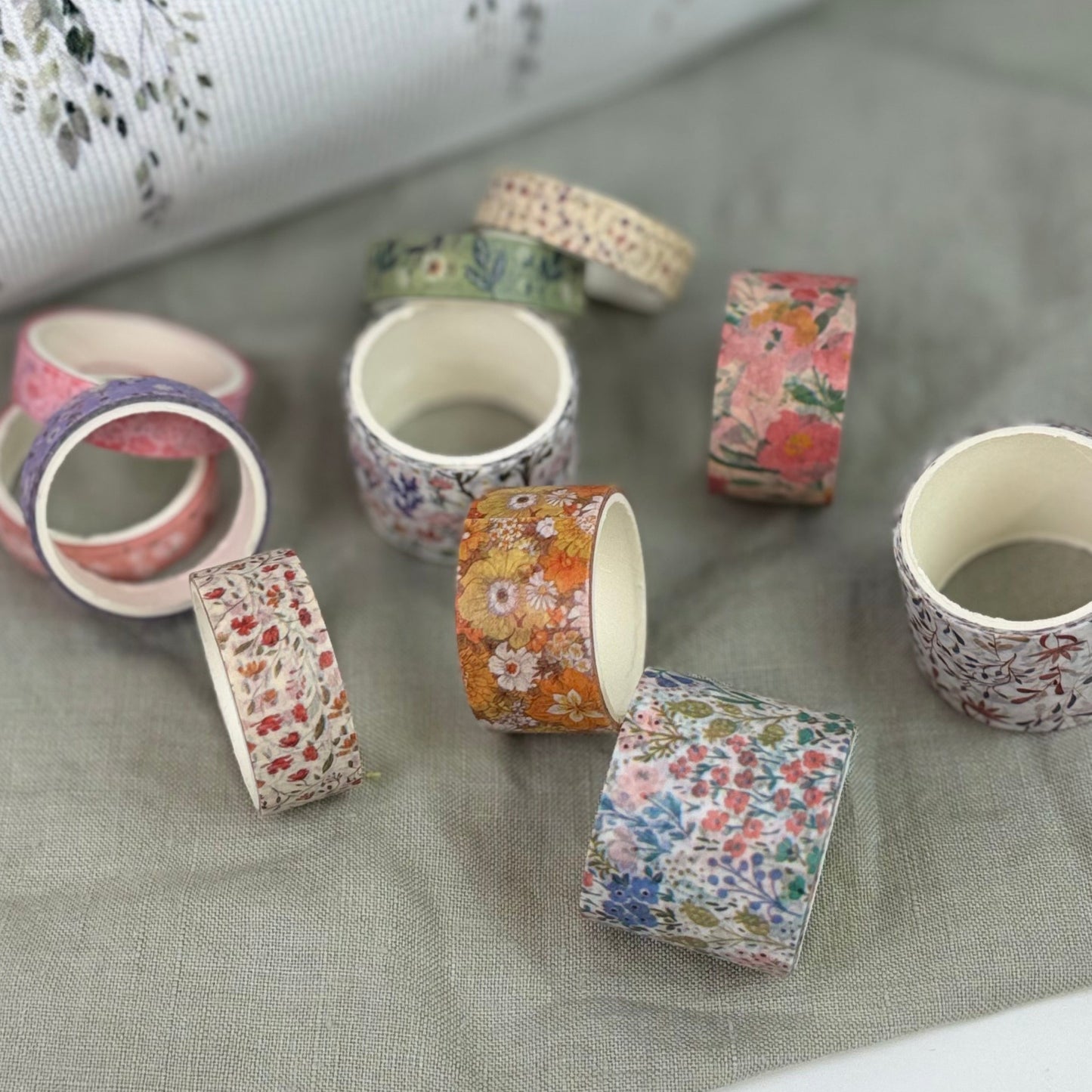 Decorative tape rolls with floral patterns on a textured surface